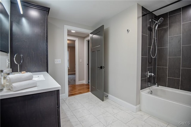 full bathroom featuring shower / bathing tub combination, vanity, marble finish floor, and baseboards