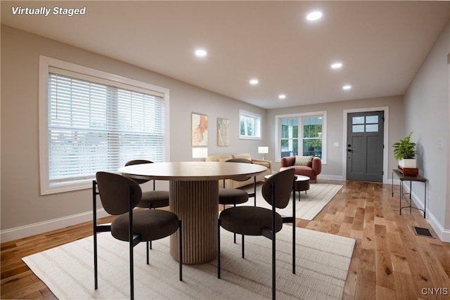 dining room featuring baseboards, visible vents, light wood finished floors, and recessed lighting