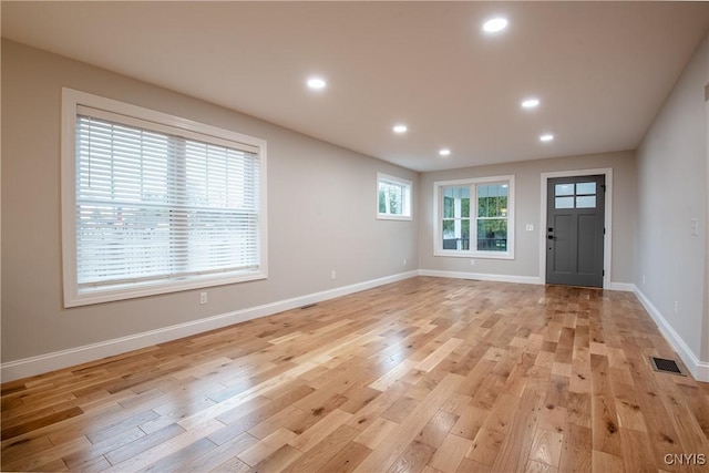 interior space with light wood finished floors, recessed lighting, and visible vents