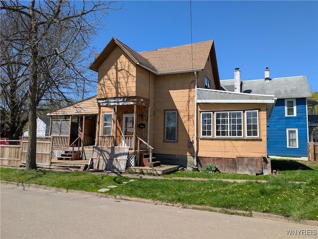 view of front of property with a chimney, fence, and a front lawn
