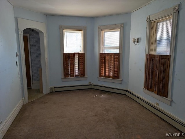 carpeted spare room featuring arched walkways