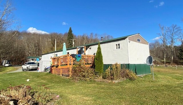 view of property exterior with a deck and a yard