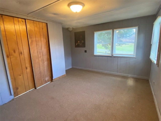 unfurnished bedroom featuring a closet, baseboards, and light carpet