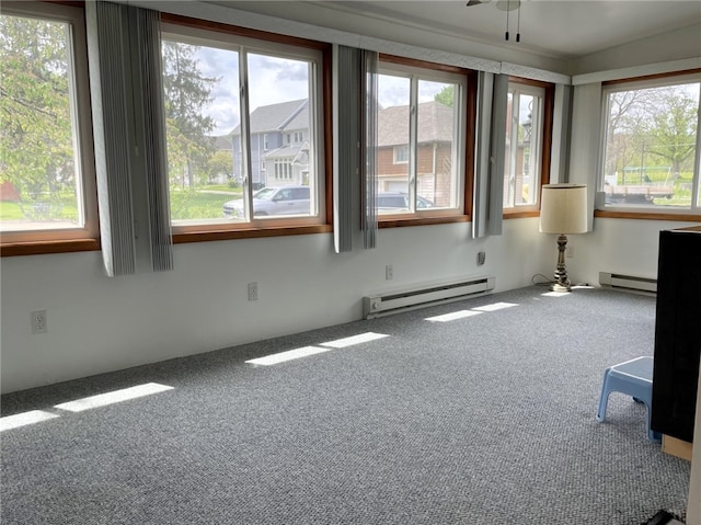interior space featuring a healthy amount of sunlight, baseboard heating, and carpet floors