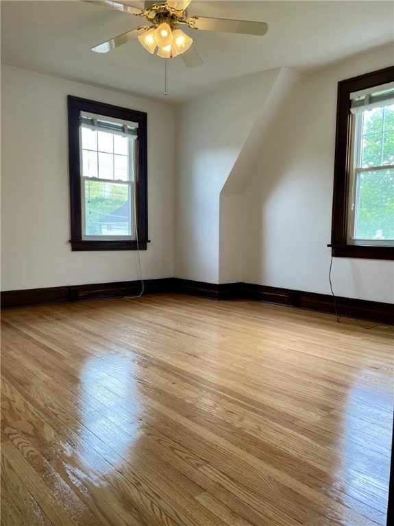 additional living space with ceiling fan, light wood-style flooring, and baseboards