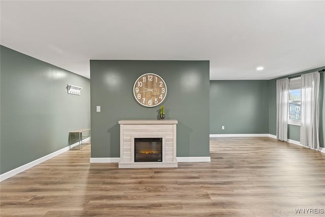 65 Guilford Ln Unit 5, Amherst, NY 14221 - unfurnished living room featuring baseboards, recessed lighting, wood finished floors, and a glass covered fireplace