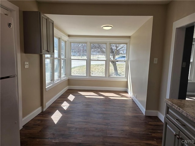 4844 Onondaga Rd, Onondaga, NY 13215 - unfurnished dining area featuring dark wood-style flooring, baseboards, and a healthy amount of sunlight