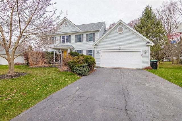 view of front facade with a garage, a front lawn, and aphalt driveway