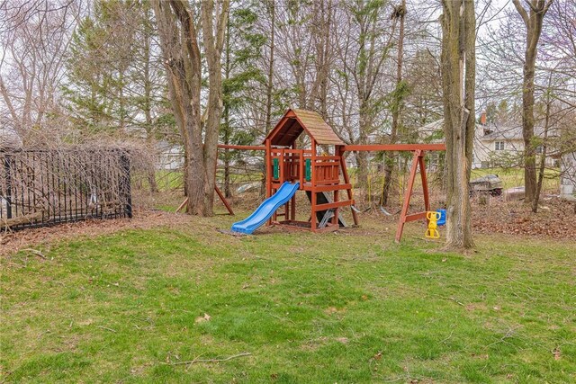view of playground featuring a lawn and fence