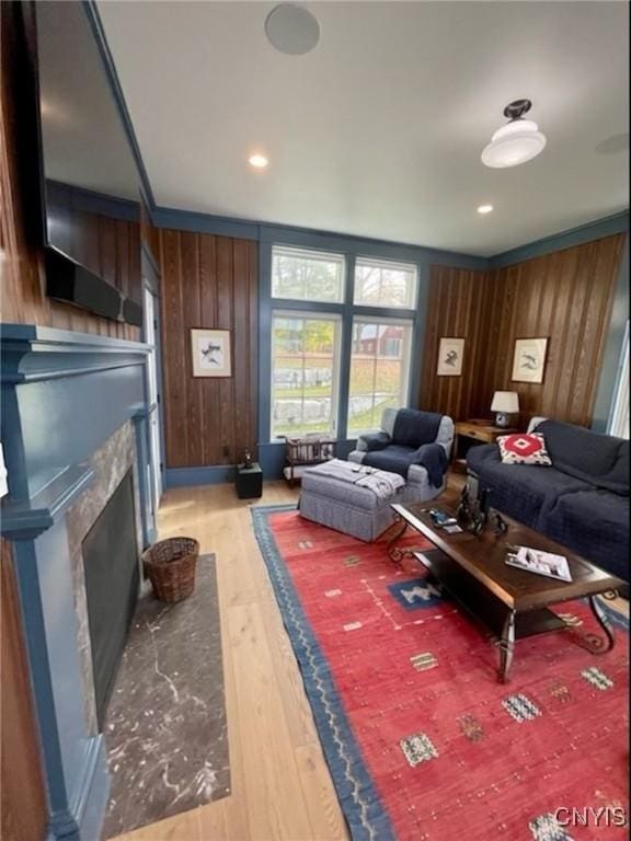 43335 Schoolhouse Rd, Clayton, NY 13624 - living area with wooden walls, light wood-type flooring, and a fireplace with flush hearth