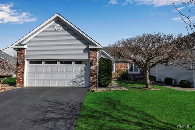single story home with a front lawn, brick siding, and aphalt driveway