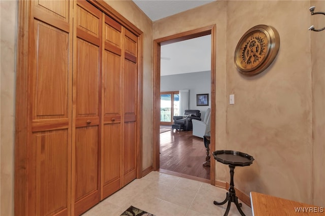 hall with light tile patterned floors and baseboards