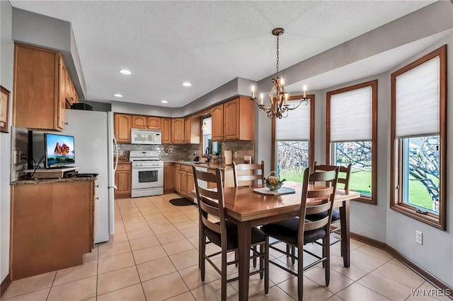 dining area featuring a chandelier, recessed lighting, light tile patterned flooring, and baseboards