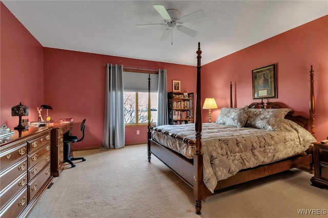 bedroom featuring light colored carpet, a ceiling fan, and baseboards