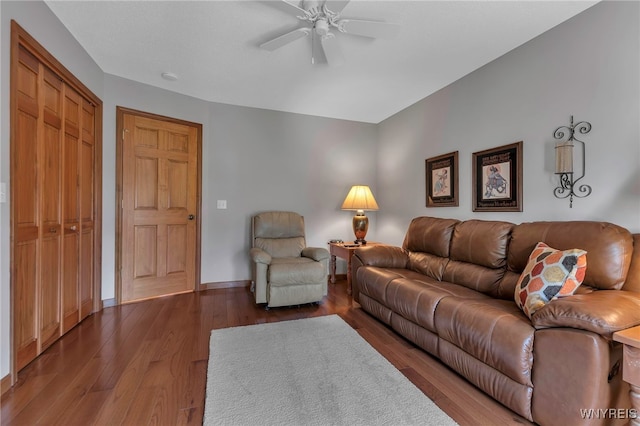 living area featuring a ceiling fan, wood finished floors, and baseboards