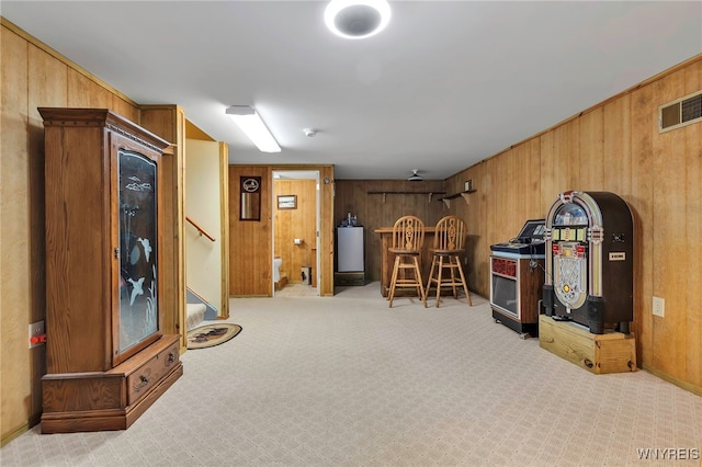 interior space with stairway, visible vents, wooden walls, and carpet flooring