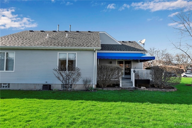 back of house with a porch, a shingled roof, and a yard