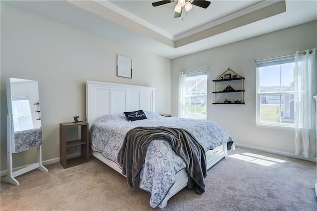 bedroom with baseboards, ornamental molding, light carpet, and a raised ceiling