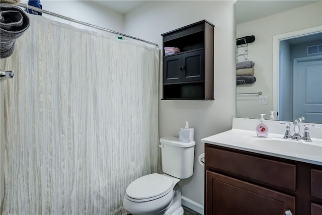 bathroom featuring vanity, toilet, visible vents, and a shower with shower curtain
