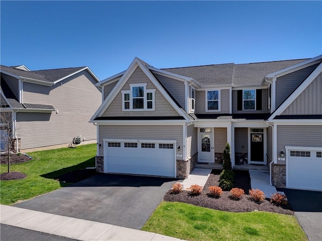 craftsman-style home with a front lawn, stone siding, a garage, and aphalt driveway