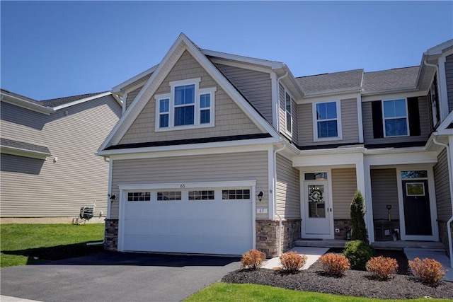 craftsman-style home featuring a porch, driveway, stone siding, and a garage
