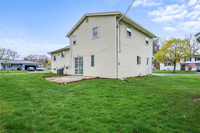 rear view of property featuring central air condition unit, a yard, and a patio area