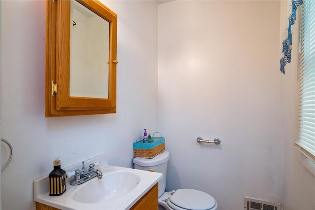 bathroom with toilet, visible vents, and vanity