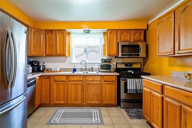kitchen featuring a sink, appliances with stainless steel finishes, and brown cabinetry