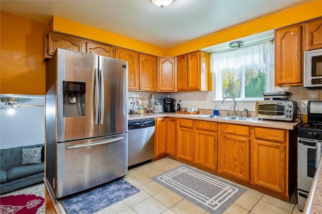 kitchen with brown cabinets, a sink, stainless steel appliances, light countertops, and a toaster