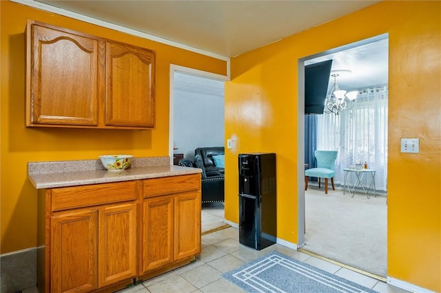 kitchen featuring light tile patterned flooring, brown cabinets, light countertops, and a notable chandelier