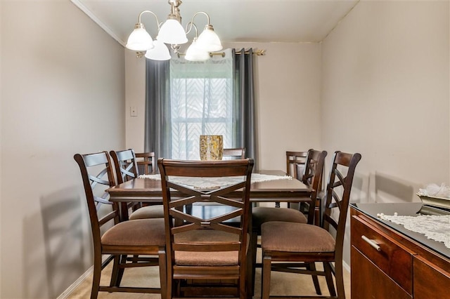 dining room with ornamental molding, a chandelier, and baseboards