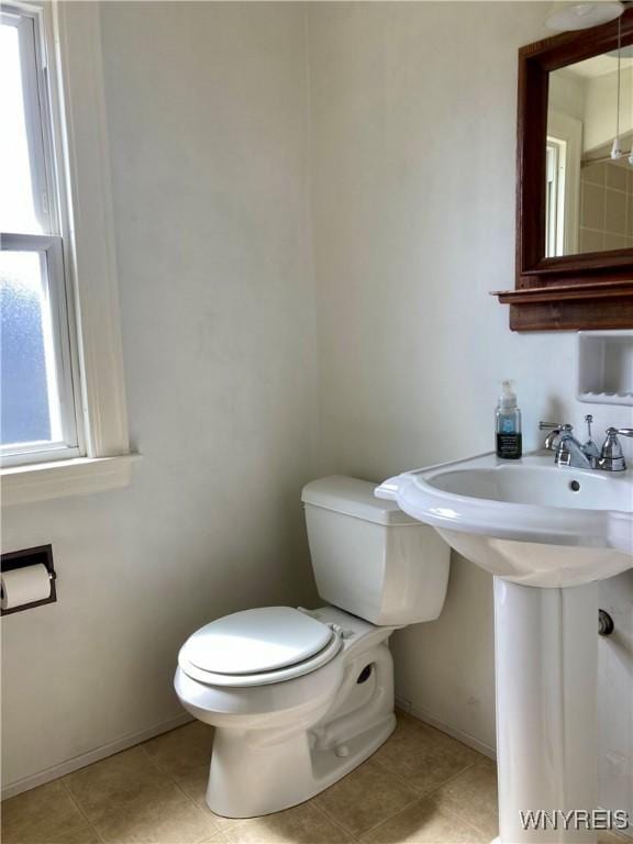 bathroom with toilet, tile patterned floors, and baseboards
