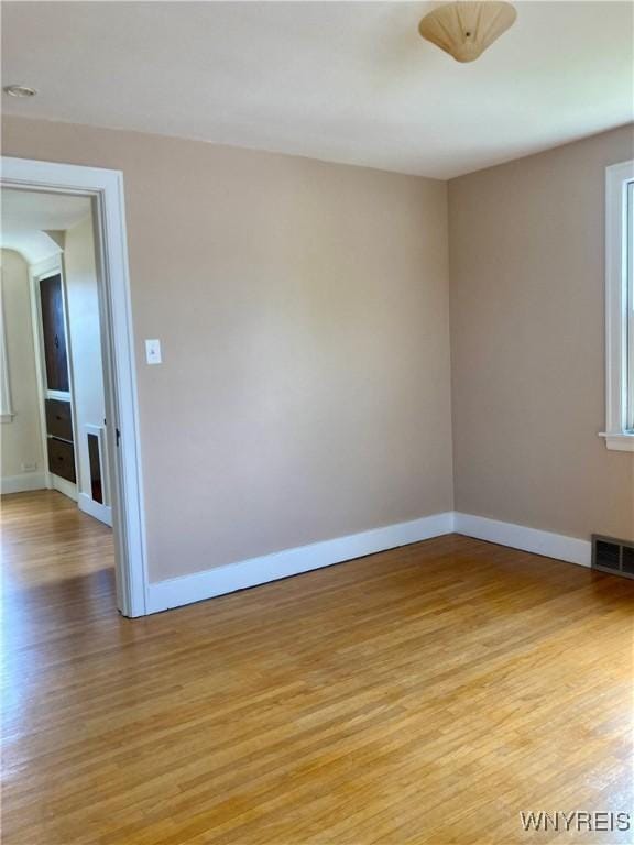 unfurnished room with visible vents, baseboards, and light wood-type flooring