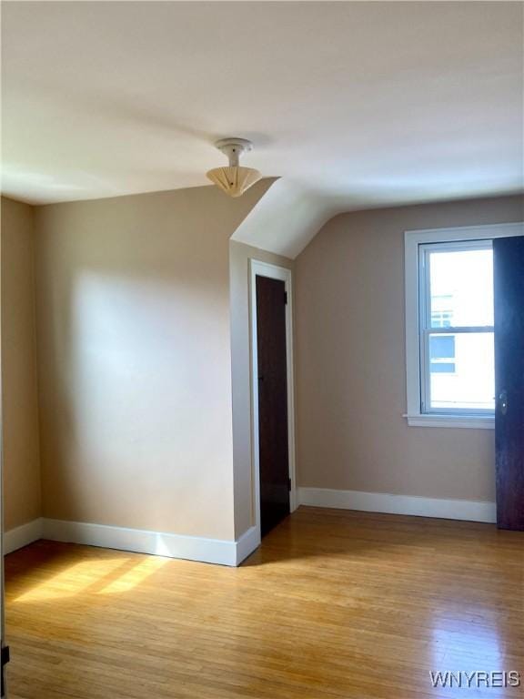 bonus room featuring baseboards, wood finished floors, and lofted ceiling
