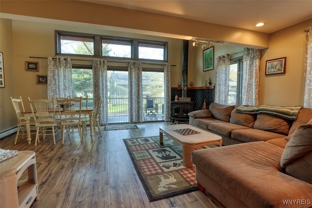 living area with hardwood / wood-style floors, a wood stove, and recessed lighting