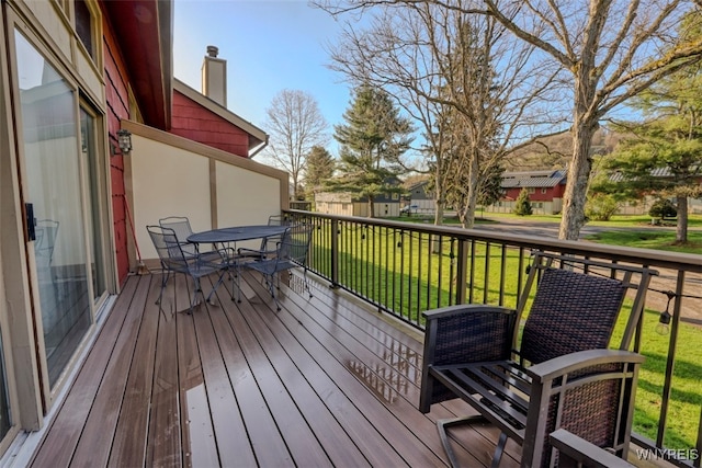 wooden deck featuring a residential view, outdoor dining area, and a yard