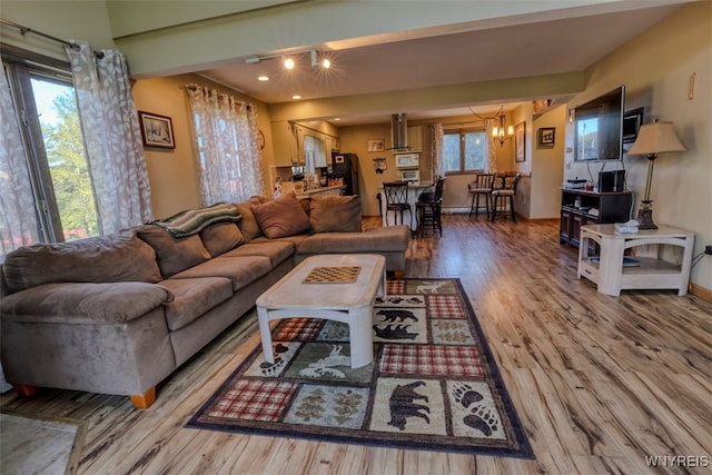 living room featuring recessed lighting, an inviting chandelier, wood finished floors, and baseboards