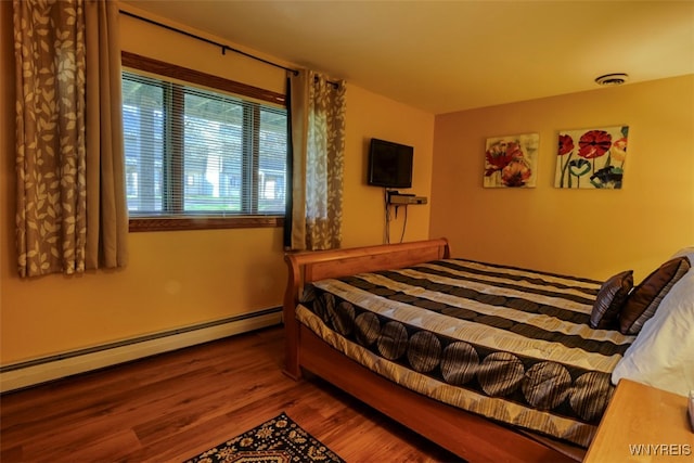 bedroom featuring visible vents, wood finished floors, and a baseboard radiator