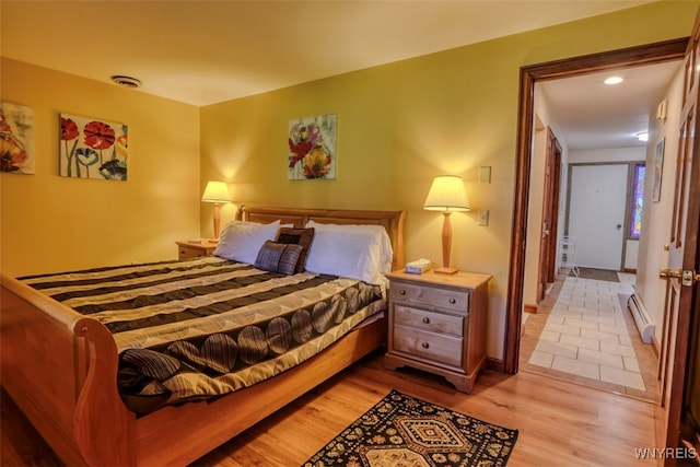 bedroom with visible vents, recessed lighting, baseboard heating, baseboards, and light wood-type flooring