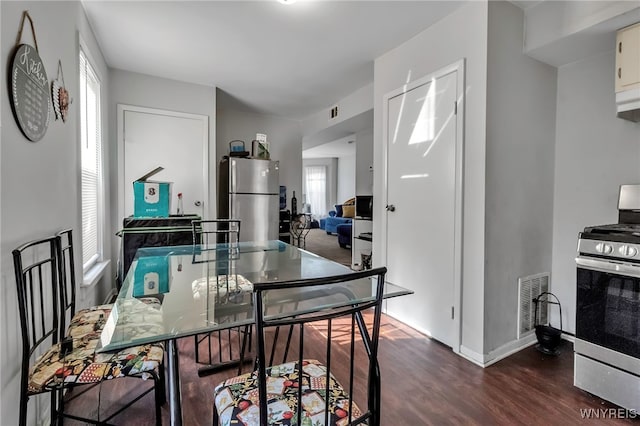 dining room featuring visible vents, baseboards, dark wood-style flooring, and a healthy amount of sunlight