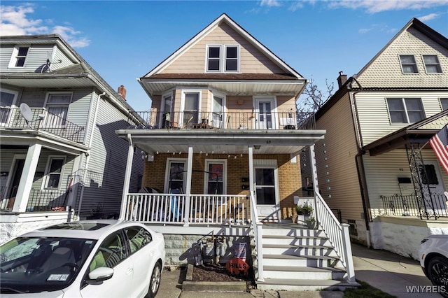 view of front of home with a porch, stairway, a balcony, and brick siding