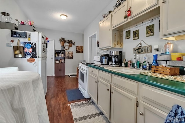 kitchen with a sink, white appliances, light countertops, white cabinets, and dark wood finished floors