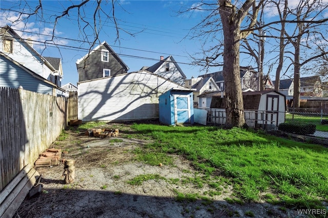 view of yard featuring an outbuilding, a shed, and a fenced backyard