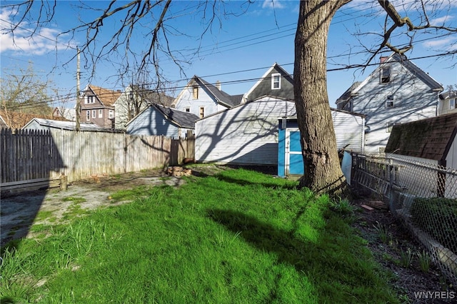 view of yard with a storage shed, an outbuilding, and a fenced backyard