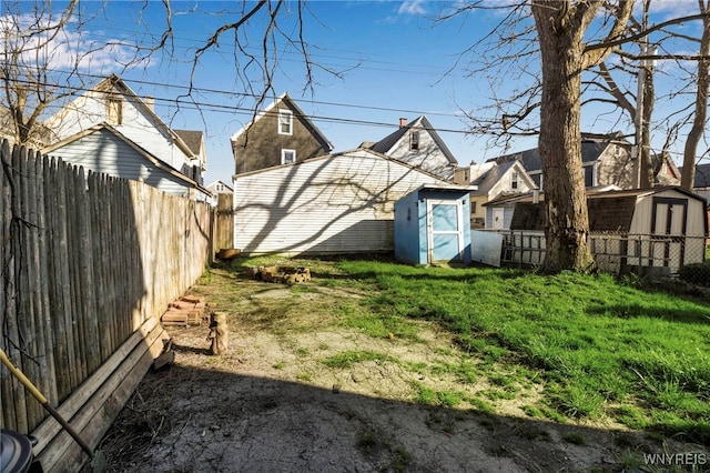 view of yard with an outdoor structure, a storage unit, and a fenced backyard