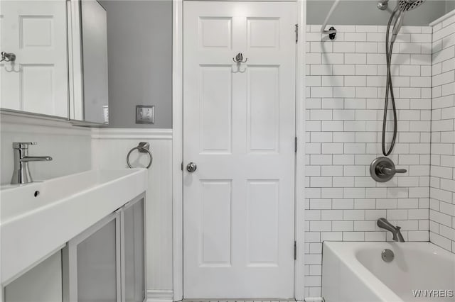 full bathroom with a wainscoted wall, shower / bathtub combination, and vanity