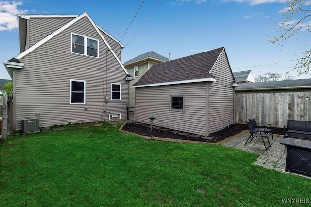 back of house featuring an outdoor structure, a yard, fence private yard, central air condition unit, and a patio