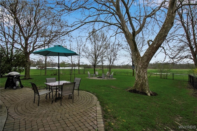 view of yard with fence, outdoor dining space, and a patio area