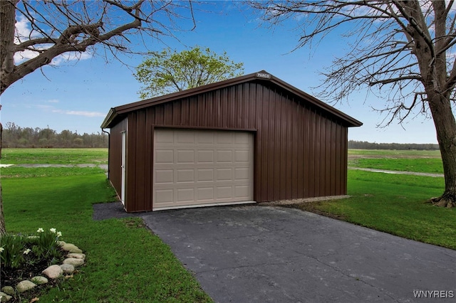 detached garage with a rural view and driveway