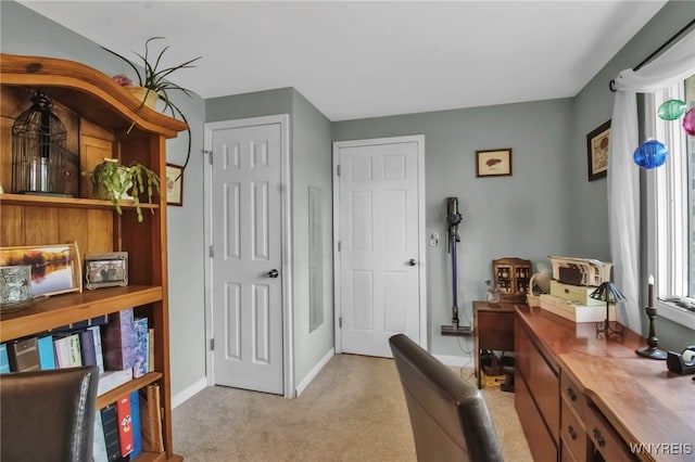 office space featuring light carpet and baseboards